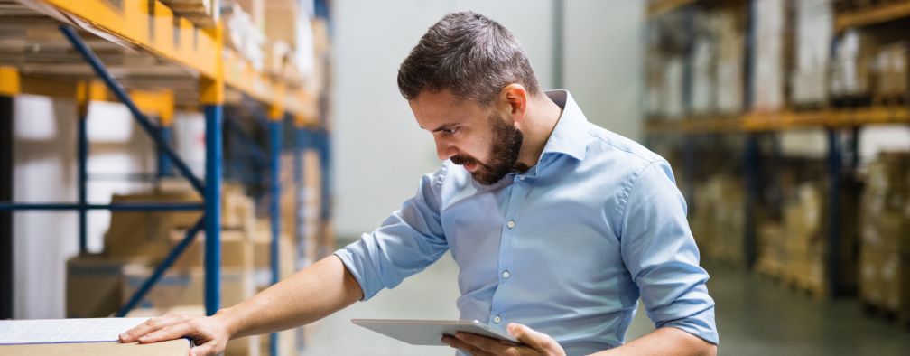 Man warehouse worker with a tablet.