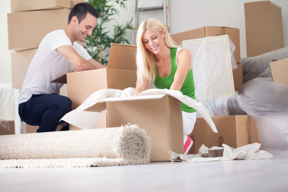 Happy young couple unpacking or packing boxes and moving into a new home.