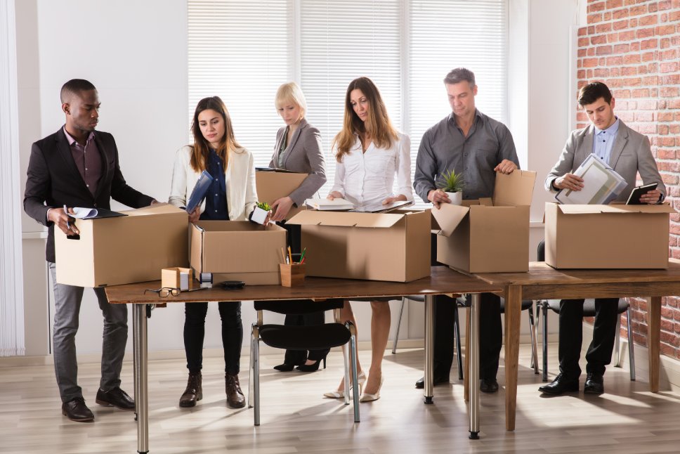 Group Of Diverse Businesspeople Packing Their Belongings In Cardboard Box At Office