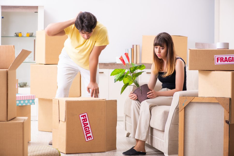 Young couple moving to new flat with fragile things