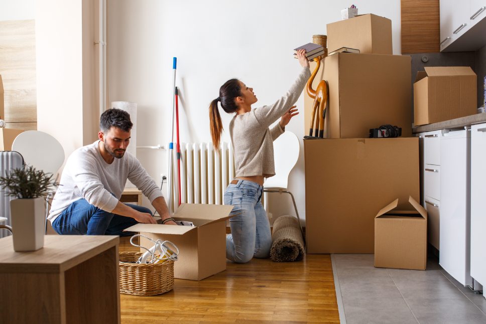 Young couple unpacking cardboard boxes at new home.Moving house.Real estate.