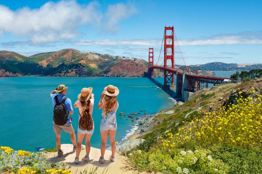 Family enjoying time together on vacation hiking trip. Golden Gate Bridge connecting San Francisco Bay and the Pacific Ocean, mountains in the background. San Francisco, California, USA