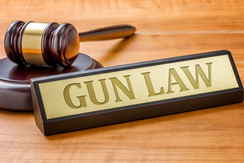 A gavel and a name plate with the engraving Gun Law