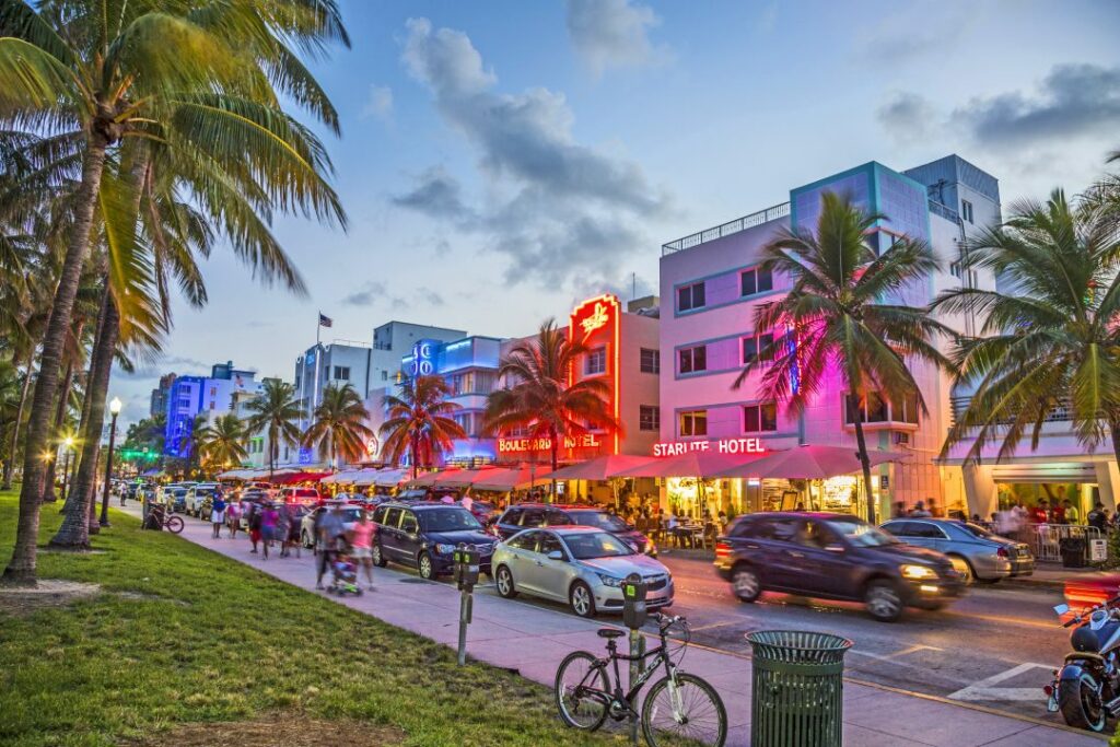 MIAMI, USA - AUG 23, 2014: people enjoy Palm trees and art deco hotels at Ocean Drive by night. The road is the main thoroughfare through South Beach in Miami, USA.