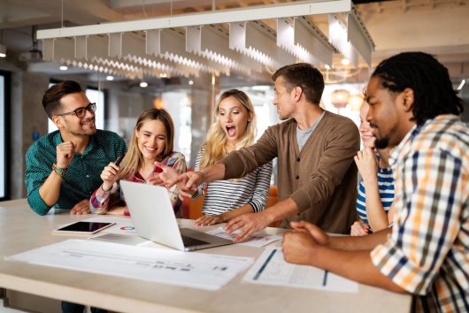 Successful group of designers, business people at work in office