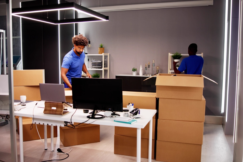 Professional Movers Packing Boxes In Modern Office