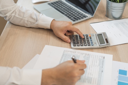 Close up hand of stress asian young employee business man, male calculate tax income and expenses, bills, credit card for payment or payday on table at home office. Financial, finance people concept.
