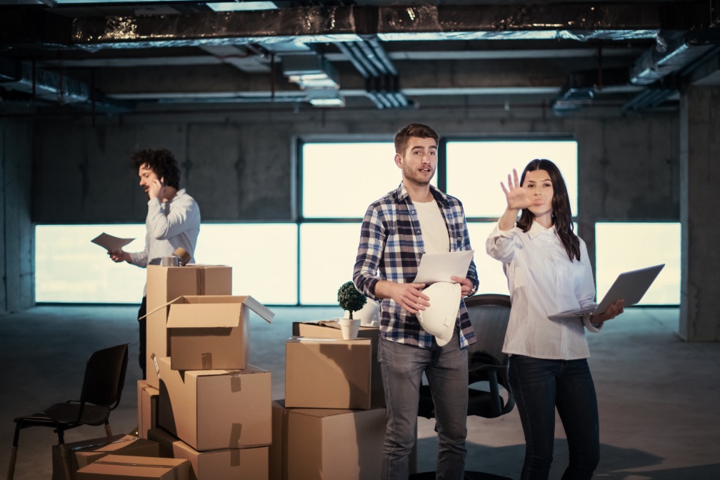 young team of business people in group, architect and engineer on construction site checking documents and business workflow using laptop computer in new startup office