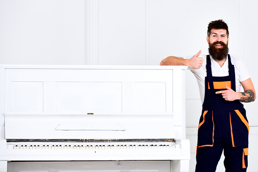 Piano mover with a white big piano. Oakley: special items movers