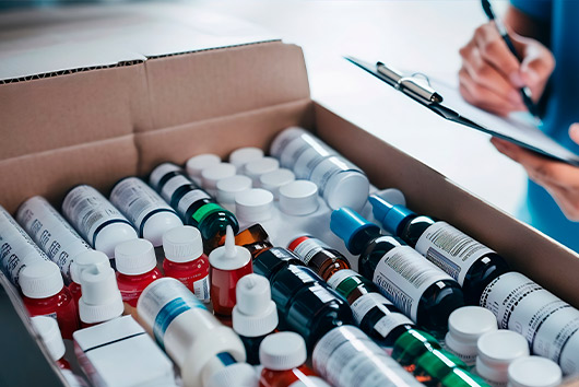 Peron doing inventory and annotations about a box full with medicine. 