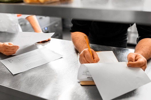 workers at kitchen checking inventory and papers