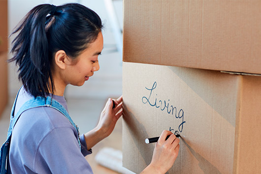 woman writing over box for a better moving