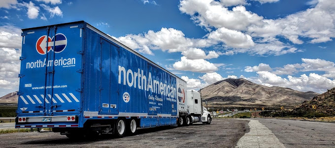 moving Truck by Oakley Relocation on USA road. Sunset behind