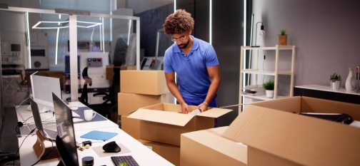 Professional Movers Packing Boxes In Modern Office