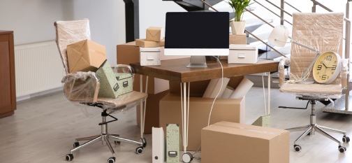 Moving boxes and furniture in new office. Commercial moving company