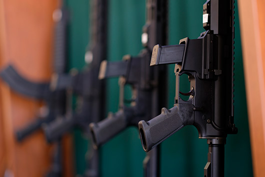 Several guns lined up against a wall, showcasing military storage solutions in San Marcos.