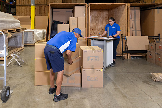 Two men in a warehouse filled with boxes, representing long-term storage solutions in San Marcos.