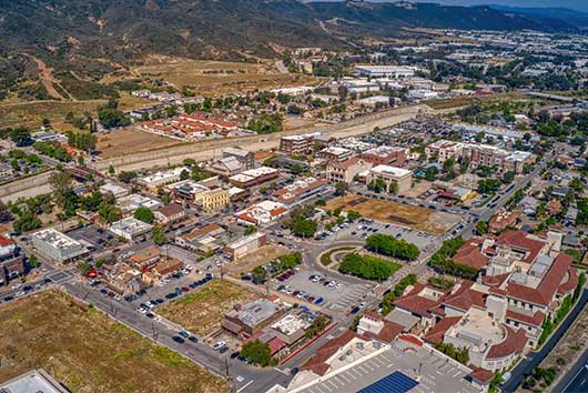 Aerial view of a city featuring a river and mountains, illustrating the landscape of Temecula, CA for relocation guidance.