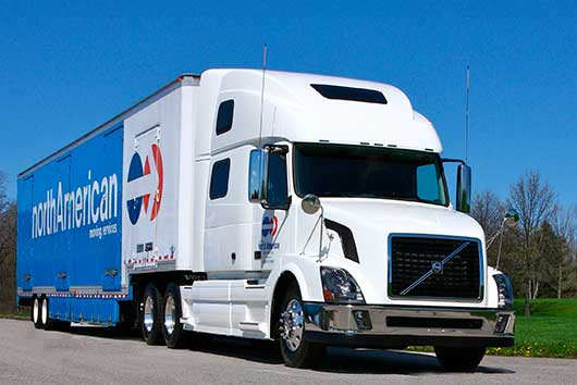 A large white semi truck driving on a road, featured in 'The Lazy Man's Guide to Relocating to Temecula, CA.'