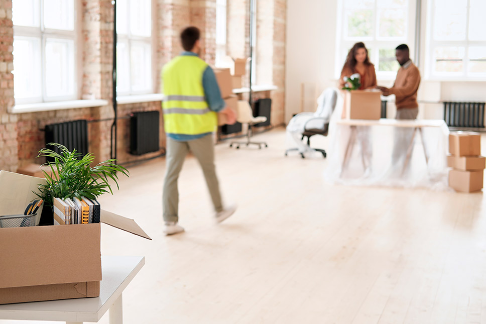 A man navigates an office space filled with boxes, indicating a government relocation in San Diego.