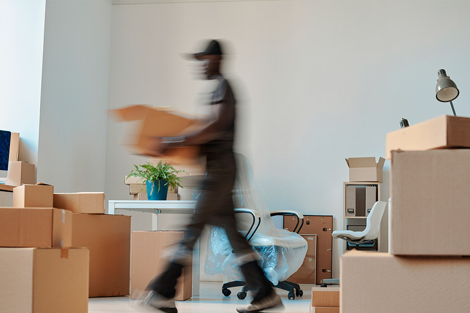 A man navigates an office space filled with boxes, indicating a government relocation in San Diego.