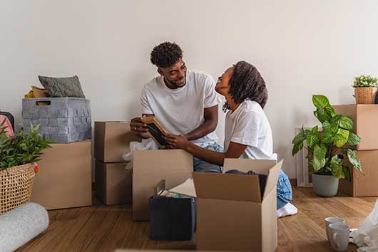 a  couple unpacking boxes in their new Charlotte home, celebrating their move from San Diego.