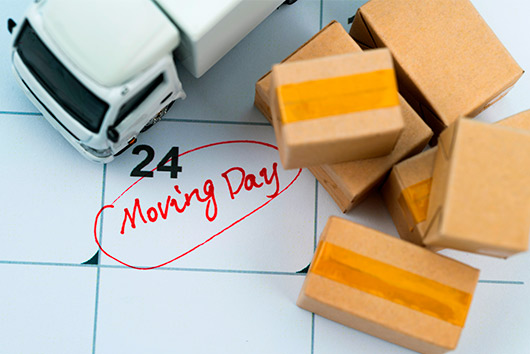 A busy moving day scene, with boxes and furniture being loaded for a move from San Diego to Nashville, TN.